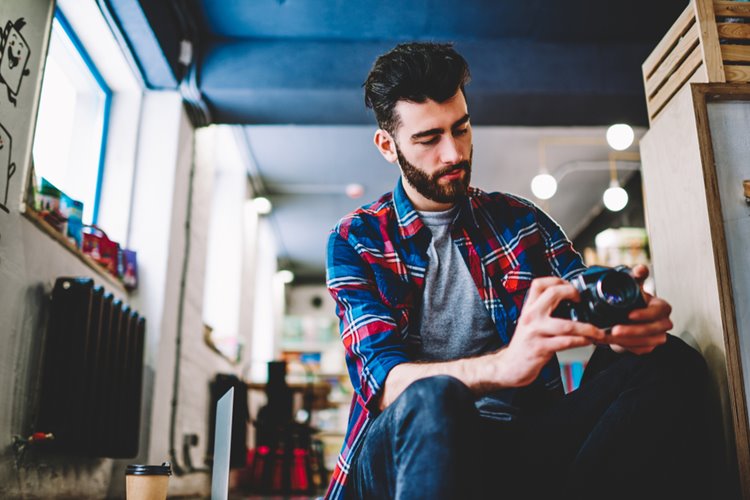 young man trying to work professional camera