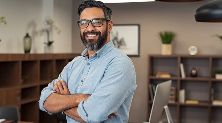 smiling man looking at camera with arms crossed