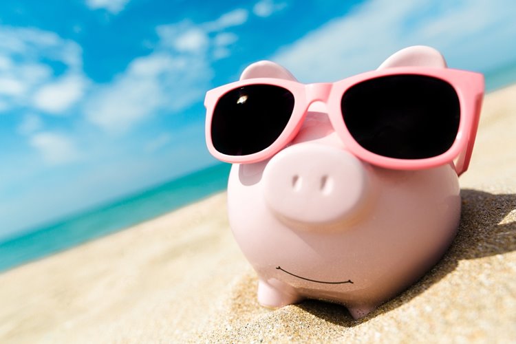 piggybank on the beach with sunglasses